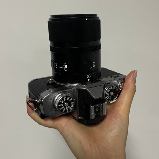 Камера Nikon Z fc с объективом Yongnuo AF 33mm f/1.4 Z в руке