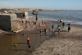 People play in the Swakop River as it flows into the Atlantic