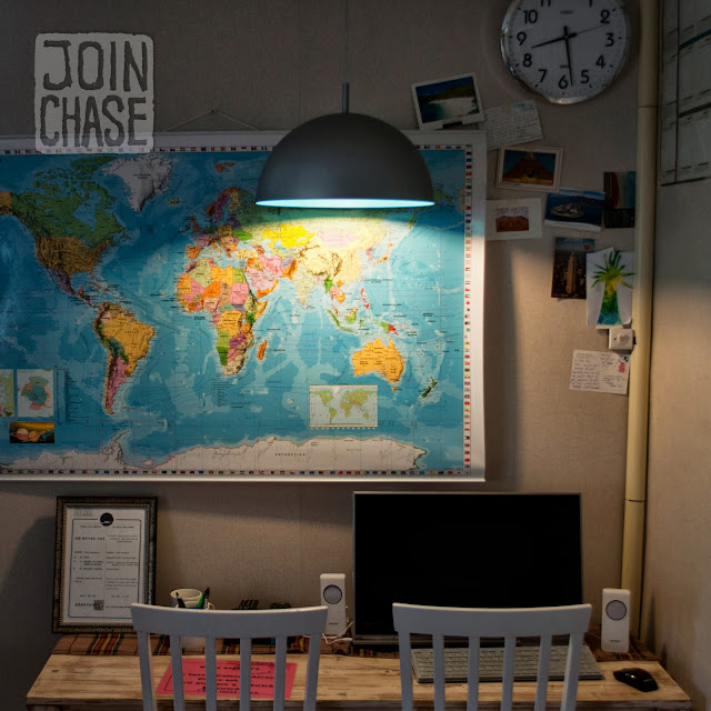 A world map on a wall with postcards and a computer at Pedro's House in Gwangju, South Korea.