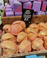 A photo of a bunch of rabbit shaped bath bombs with a gold overlay on top with a black card with gold rabbit bath bomb lush in white font on a bright background