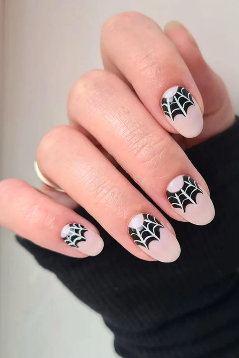 close-up of woman hand with a very cute and minimal halloween nail design with spiderweb