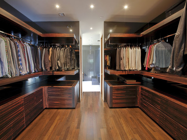 Photo of big walk in closet with dark wooden furniture 