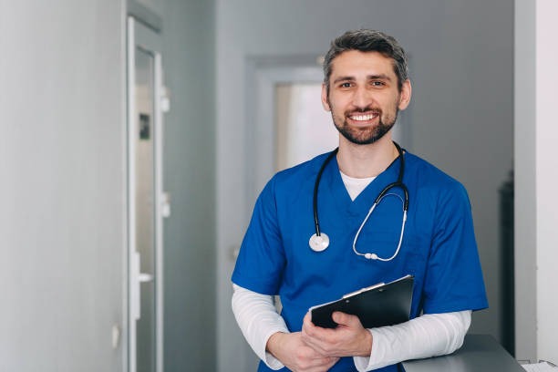 A male nurse with a stethoscope standing.