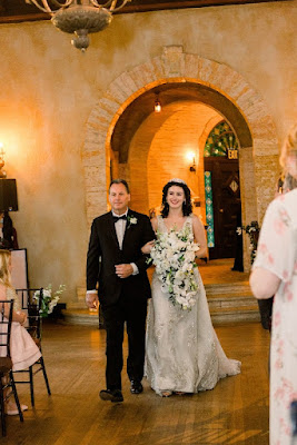 bride holding bouquet walking down the aisle with dad