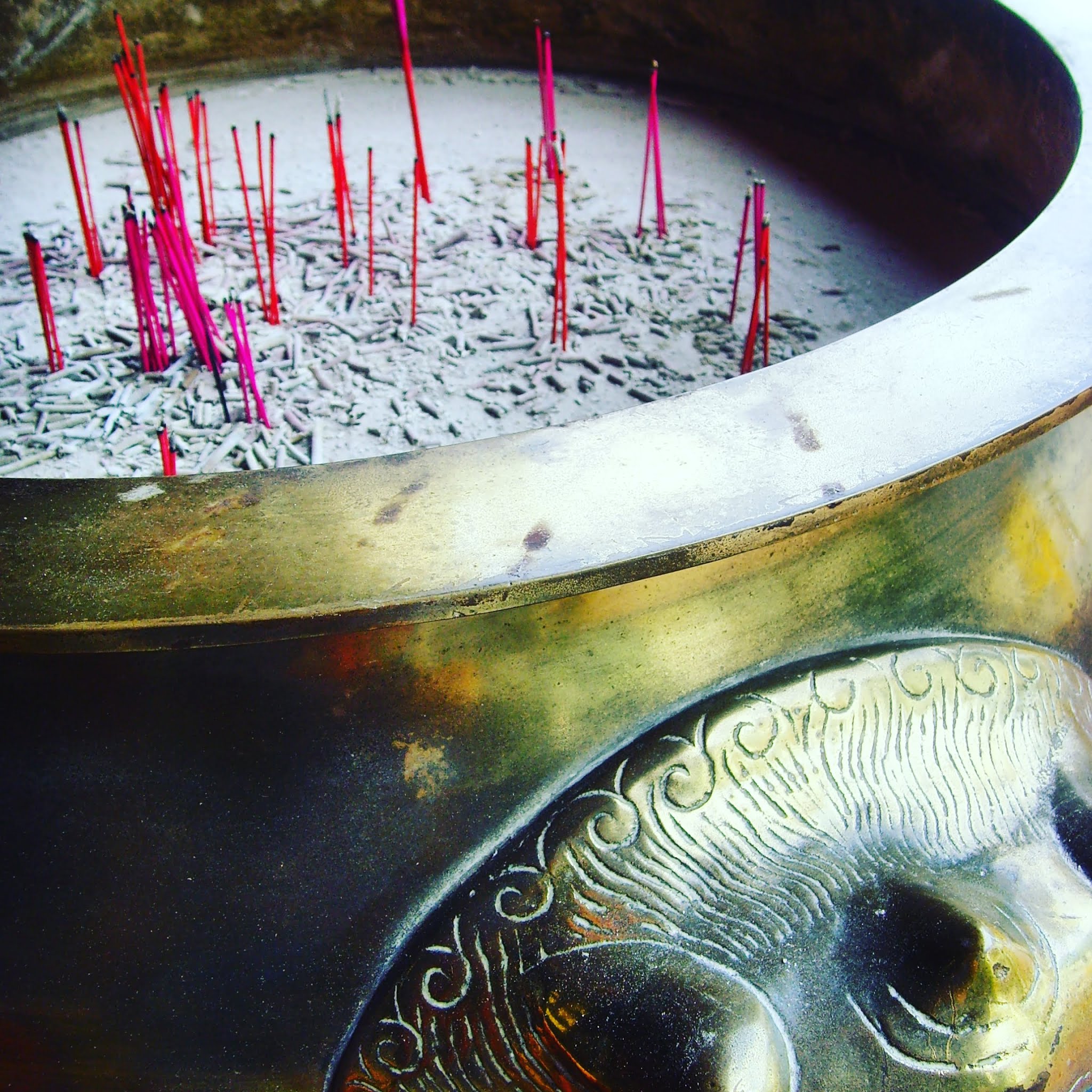 pink incense sticks in gold pot in singapore, during 48 hours in singapore you'll be met with incense everywhere
