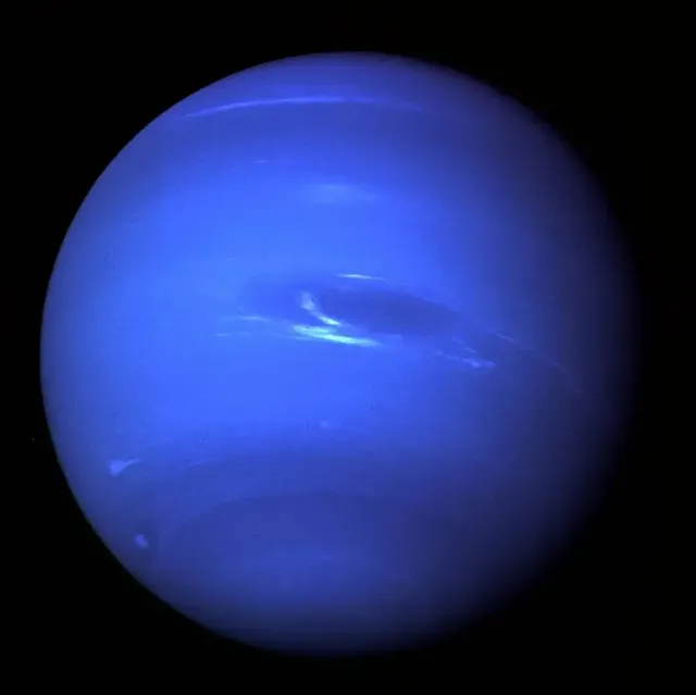 Image of Neptune captured by Voyager 2 just before its closest approach on Aug. 25, 1989, showing the Great Dark Spot storm and surrounding light-blue cloud patterns.