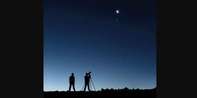 Dos siluetas observando en cielo con telescopio personal. Crédito ESO