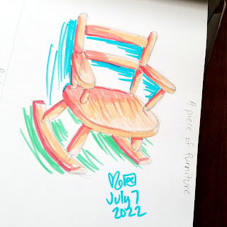 A photograph of a marker drawing in a sketchbook. The drawing is brightly colored and quickly sketched, and is of a child sized rocking chair.