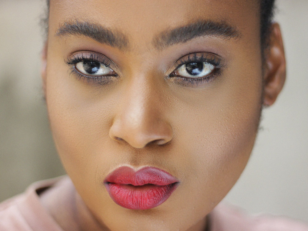 face closeup of a woman wearing a red lipstick looking into the camera