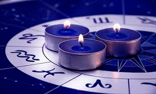 Imagen de tres velas encima del logotipo de los signos del zodiaco