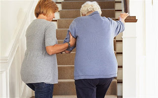 hija ayudando madre anciana a subir escaleras