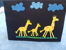 A girafa Gigi correndo no campo com mais duas amigas girafas.