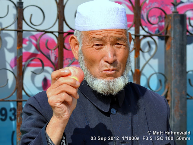 street portrait, headshot, China, Xi'an, Hui Muslims, Hui Muslim man, taqiyah, white skullcap, kufi, Muslim beard, rose apple, liánwù