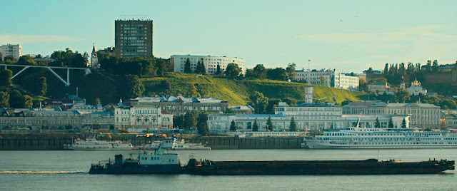 Город на берегу реки и проплывающая баржа