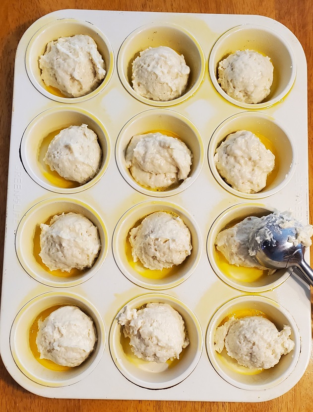 sour cream raw batter in a muffin tin ready for baking