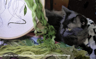 Black cat helping with crewel embroidery