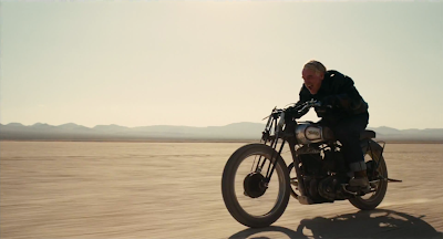 Philip Seymour Hoffman as Lancaster Dodd in The Master, rides a bike in the desert, directed by Paul Thomas Anderson