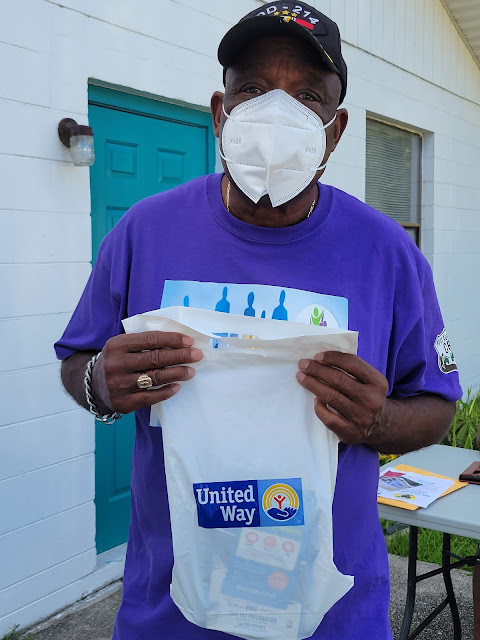 Greg White showing off a United Way gift bag being given to residents getting their Covid-19 shots