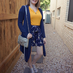 awayfromblue Instagram | navy waterfall cardigan with mustard tee and printed shorts blue and yellow SAHM style outfit with silver accessories