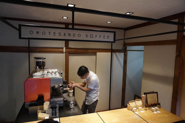 A barista carefully sprinkles cinnamon over a cup of latte at Omotesando Koffee in Tokyo