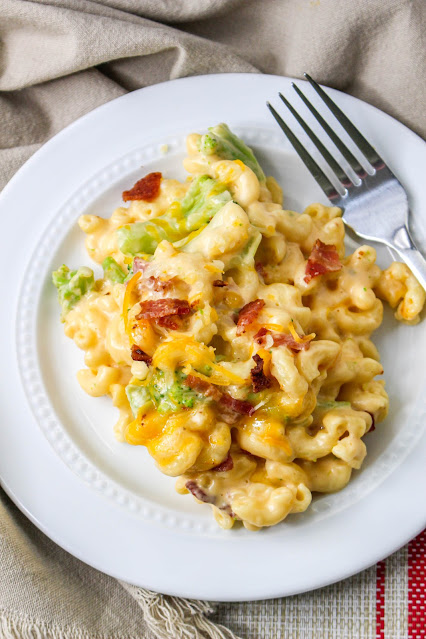 macaroni and cheese with a fork on a white plate.