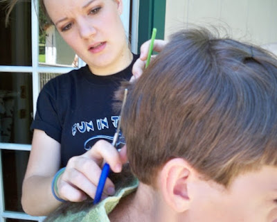 Rebekah trims the base line of Christian's hair before feathering/layering.