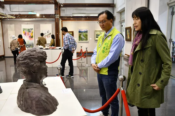 ▲太陽文化藝術協會理事長李雪蘭向林世賢市長解說會員聯展作品。（記者林明佑翻攝）