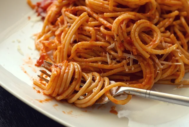 Spaghetti on a plate with a fork.