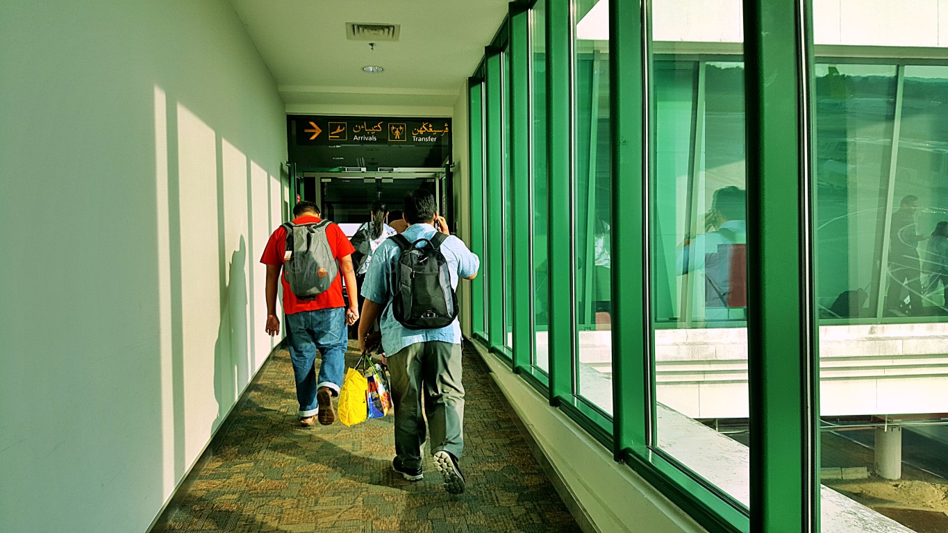 view of passengers walking from the plane to the airport's main arrival floor at Brunei International Airport
