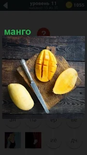 На разделочной доске манго разрезаны ножом на несколько частей