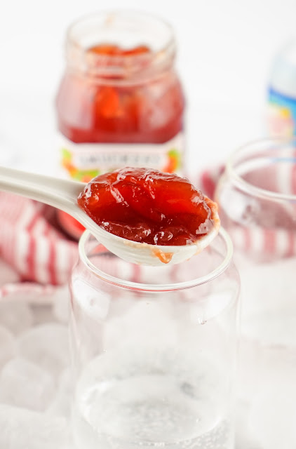 jam being scooped in a glass.