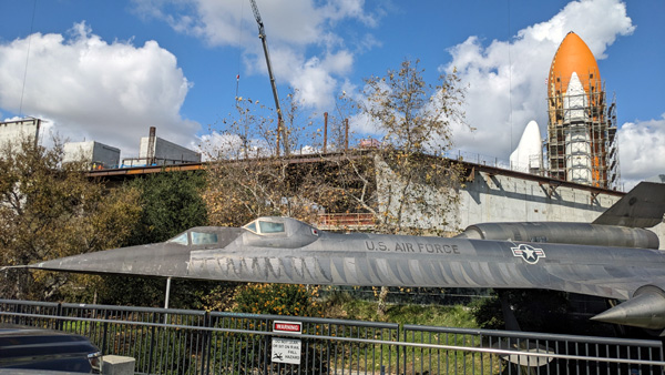 At the California Science Center in Los Angeles, a retired A-12 Blackbird photobombs Endeavour's Space Shuttle Stack as it stands tall inside the construction site for the Samuel Oschin Air and Space Center...on February 2, 2024.