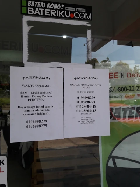 Display of operating hours for Bateriku.com branch in Taman Bukit Dahlia.