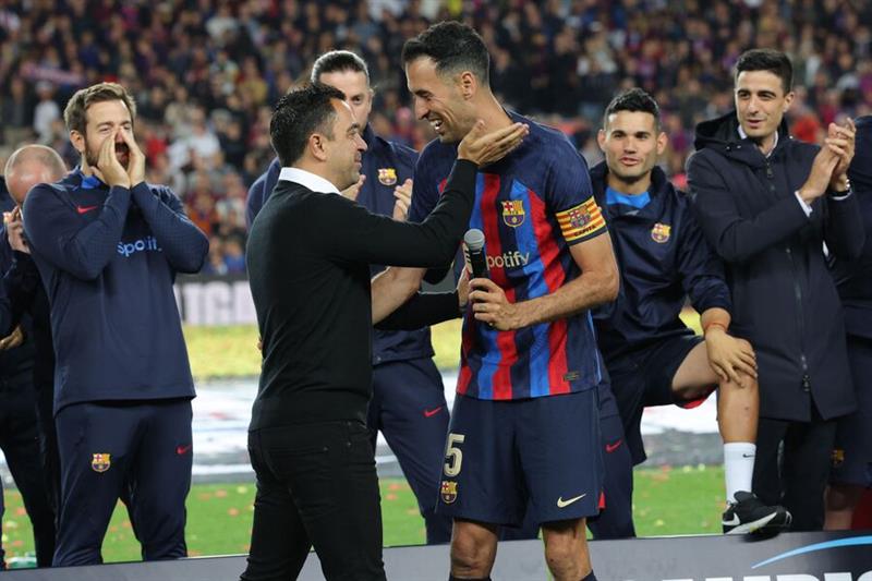 Barcelona s Spanish coach Xavi (L) greets Barcelona s Spanish midfielder Sergio Busquets