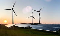 Wind turbines and solar panels in field. (Photograph Credit: Alamy) Click to Enlarge.