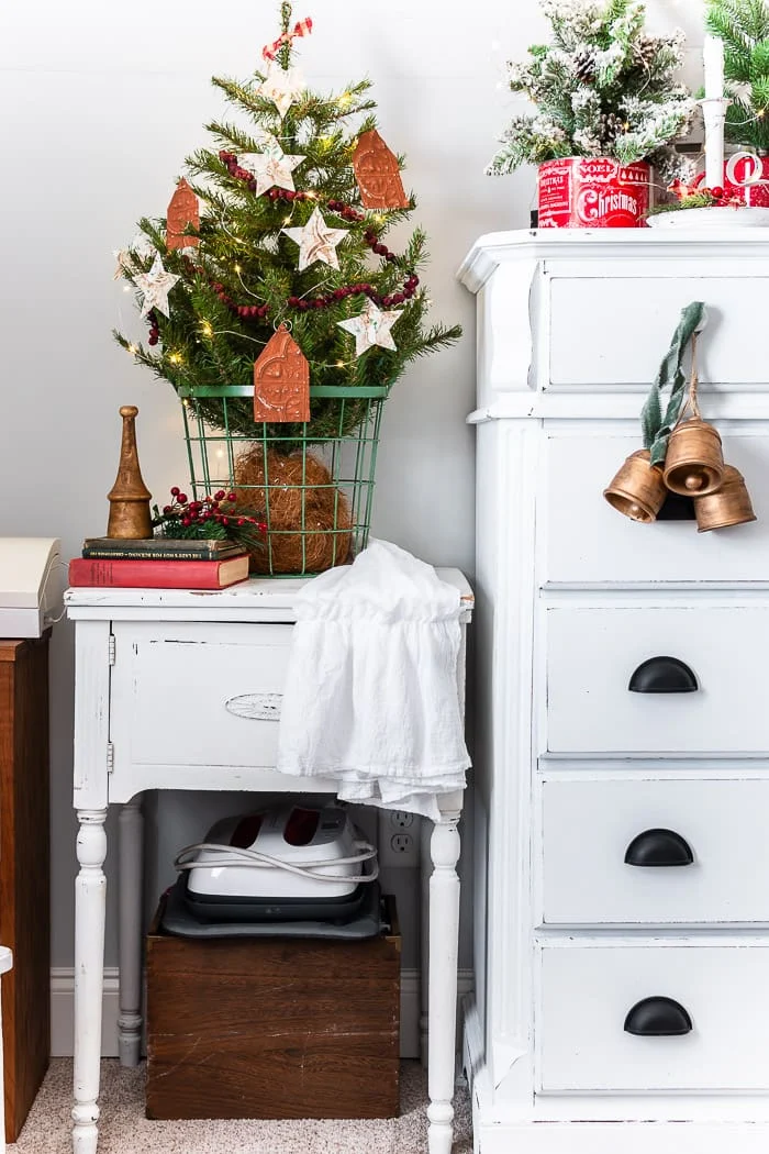 chippy white furniture, small tree, old books, berries, twinkle lights