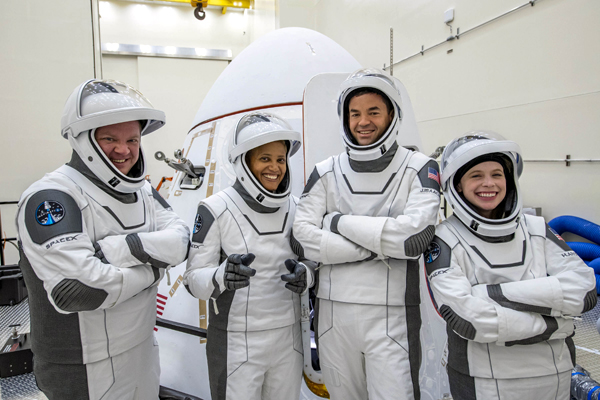 The Inspiration4 astronauts pose in front of the Crew Dragon Resilience vehicle inside SpaceX's Dragonland facility in Florida...on August 30, 2021.