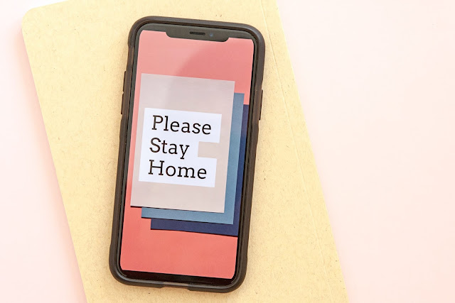 smartphone displaying the text "please stay home" during lockdown