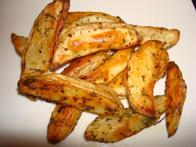Lavar bien las papas y cortar cualquier cosa que se vea mala en la papa. Dejar la piel Es más sano y nutritivo comerlas con la pile. Cortas las papas en palitos o cuñas. Sazonar las papas con un poquito de orégano, perejil, sal, pimienta y revolver con un poquito de aceite. Precalentar el horno a 425° F. - 218° C. Una bandeja de hornear cubrir con un capa delgada de aceite de vegetal y poner en el horno a calentar. Cuando está bien caliente poner las papas en la bandeja y cocinar por 1 hora. Cada 20 minutos dar vuelta las papas para que se doren por todos lados.  CONSEJO: Para dar vueltas las papas use una espátula de parchar paredes (nueva por supuesto) es lo mejor. Si usa otros utensilios puede romper las papas al darles vueltas o sacarlas.
