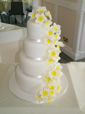 Three tier round wedding cake with frangipanis