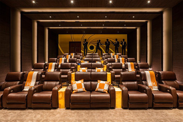 Còn đây là phòng chiếu phim tại gia, với 40 chỗ ngồi, và hình trang trí lấy cảm hứng từ Điệp viên 007 ở tường sau.