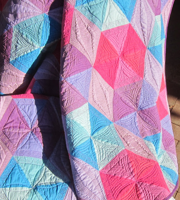 http://quiltparadigm.blogspot.com/2014/05/halographic-hexigonal-triangles-its-wrap.html