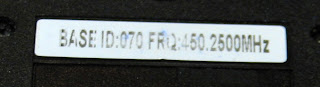 [Image: Photo of a smaller sticker on the bottom of the device, reading 'BASE ID:070 FRQ:450.2500MHZ'.]