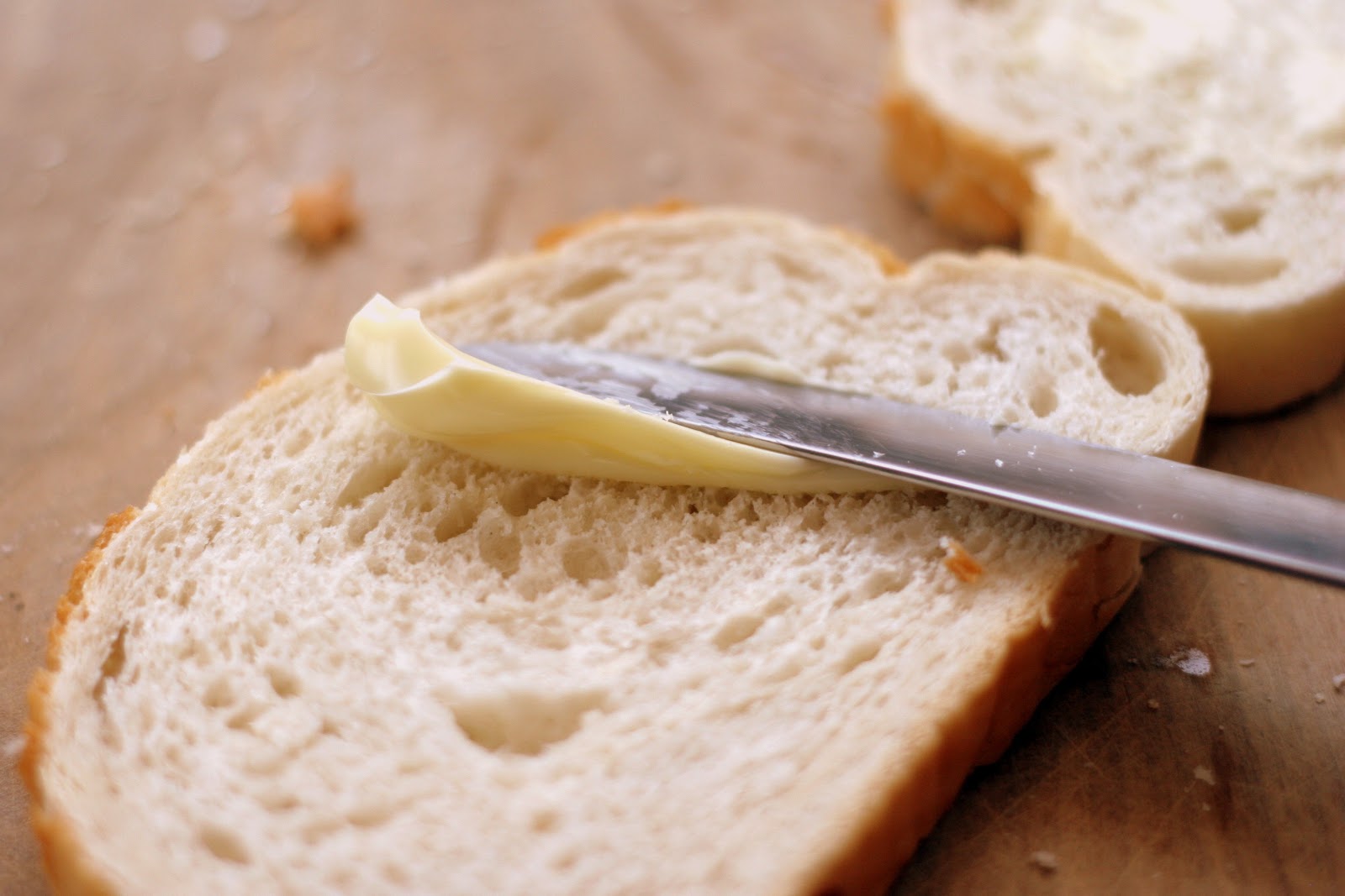 バターがパンにバターナイフで塗られている