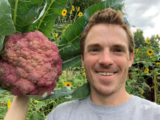 Farmer guy holding purple cauliflower