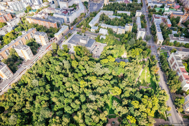 Зеленый парк среди городских массивов