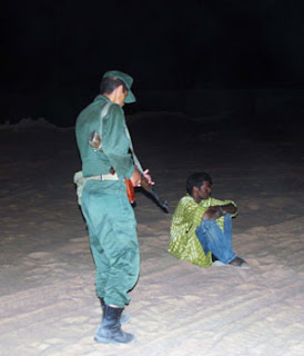 Migrante bloccato da un gendarme algerino nella notte nel deserto