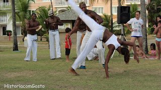  foto de roda de capoeira uma moça joga com um rapaz 