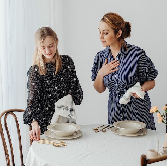 Mother and daughter setting the table