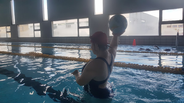 Chica en la piscina con un balón